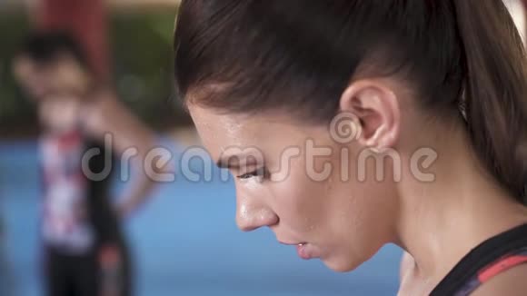 俯视图一位运动型妇女在呼吸沉重时低着头的侧视图她脸上出汗了纵断面纵向视图视频的预览图