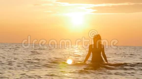 一个女人在黎明时穿着泳衣从水中出来一个女孩在海里游泳享受日出骗局视频的预览图