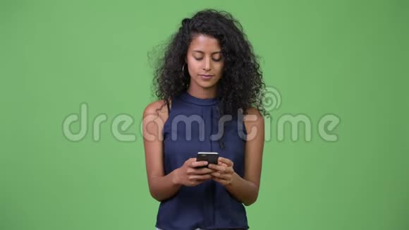 年轻漂亮的西班牙裔女商人一边打电话一边思考视频的预览图
