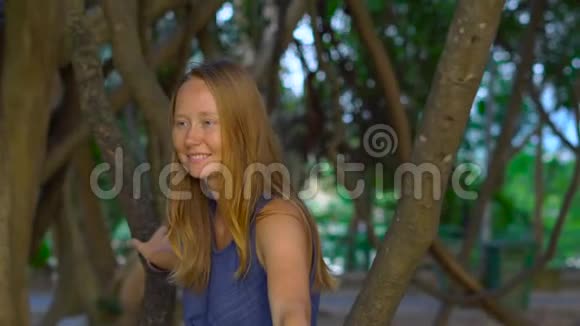 一位年轻女子坐在热带公园里的利亚纳托尼卡概念中的假日视频的预览图