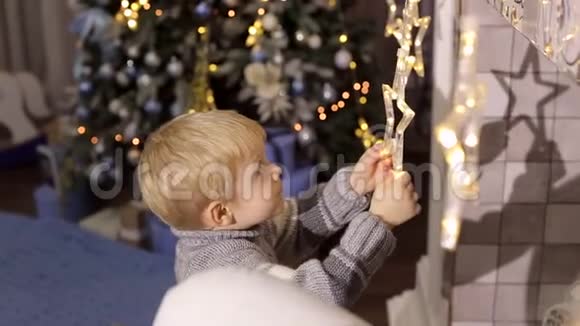 小男孩在壁炉旁玩圣诞玩具视频的预览图