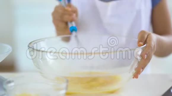 小女孩的手在碗里搅拌蛋黄视频的预览图