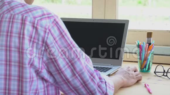 粉红斯科特衬衫商人点击鼠标或在笔记本电脑前工作视频的预览图
