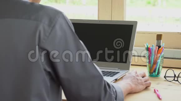 灰色衬衫商人点击鼠标或在笔记本电脑前工作视频的预览图