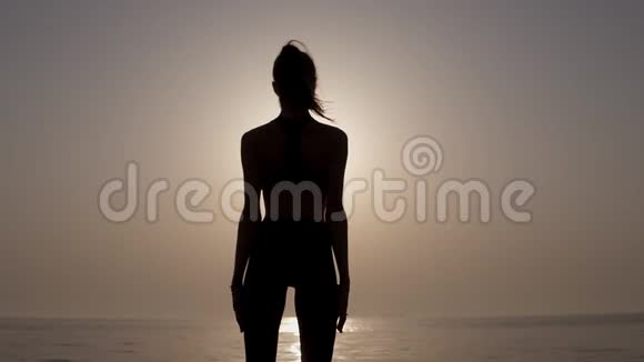 一个身材苗条身材匀称的女孩站在海边令人叹为观止就像早晨的日出坚强和有抱负视频的预览图