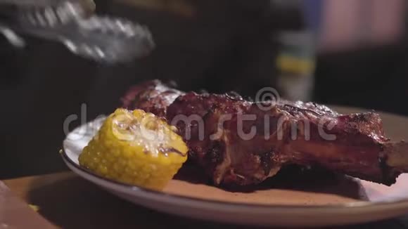 厨师戴着黑色炊具手套端在盘子里烤肉和烤玉米片上关门视频的预览图