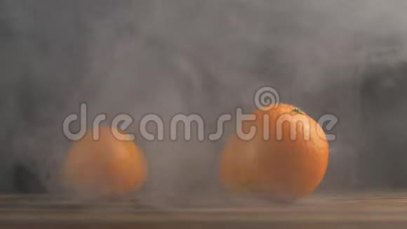 橘子卷在一张木桌上黑色背景烟雾弥漫特写慢潮背景农场曼达琳视频的预览图