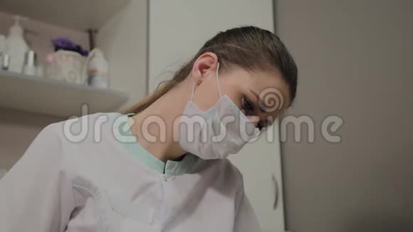 年轻的美容师戴着面具的美丽美容师的画像视频的预览图