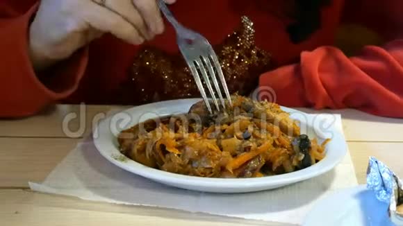 人们在餐馆或咖啡馆里吃卷心菜炖菜或带肉的大菜视频的预览图