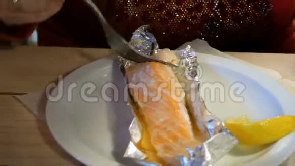 人们在餐馆或咖啡馆里用叉子烤鲑鱼视频的预览图