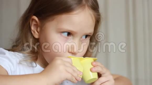 小女孩吃乳制品酸奶小孩用勺子吃奶酪肖像特写视频的预览图