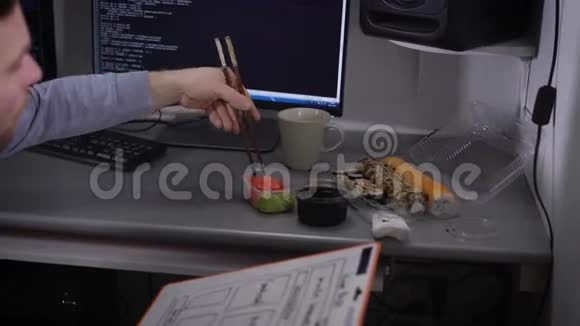 年轻的商人在午餐时间在他的桌子上吃寿司自由职业者在他的午餐休息视频的预览图