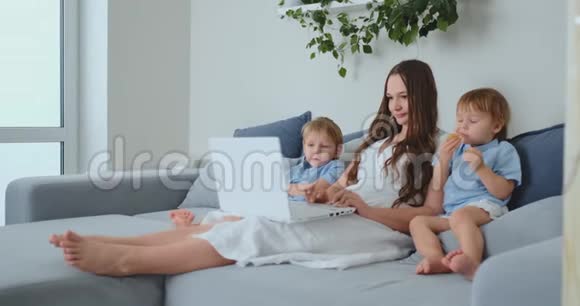 家庭幸福妈妈孩子儿子在家玩手提电脑视频的预览图