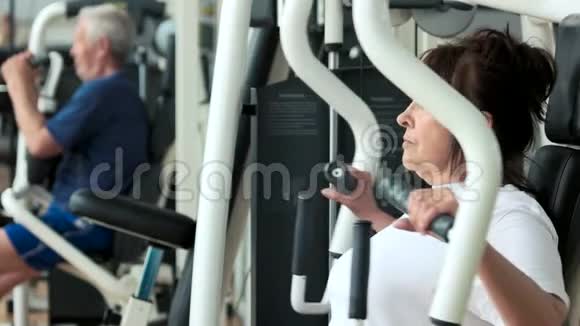 女性退休人员在健身房训练侧视视频的预览图