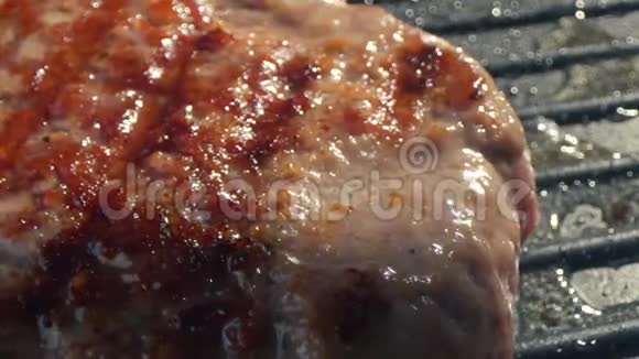特写的大牛肉切块是烤的厨师用铁铲把切块压到烤架上慢速视频视频的预览图