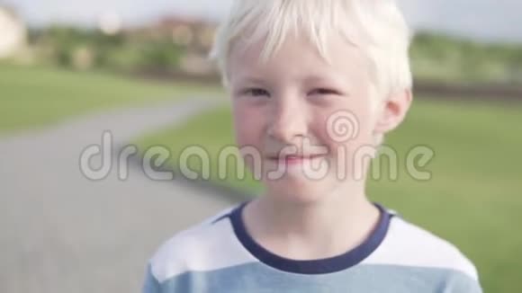 夏天可爱的金发男孩在公园散步视频的预览图