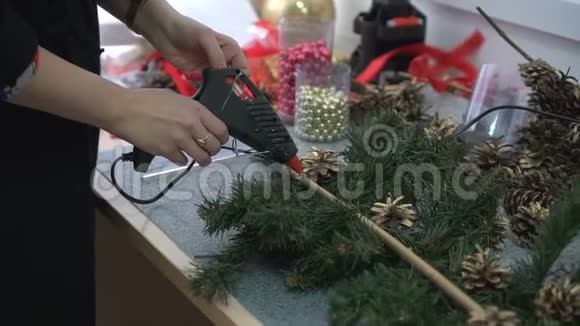 女人用松果装饰手工制作的圣诞树枝和闪亮的珠子视频的预览图