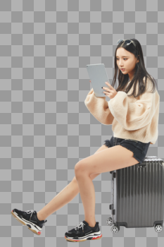 年轻女孩坐在行李箱上玩平板电脑图片素材免费下载