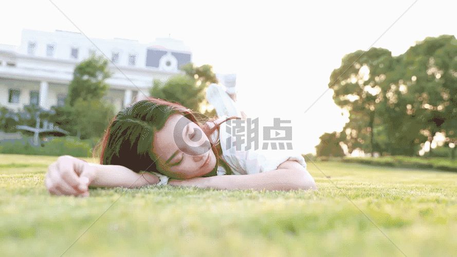 夕阳下大学生躺在草地上GIF图片素材免费下载