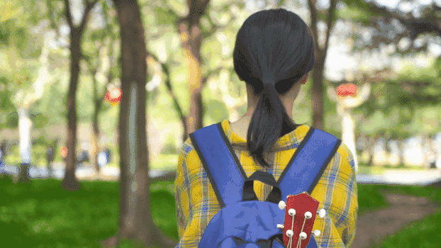 背着乐器在森林行走的女生背影GIF图片素材免费下载