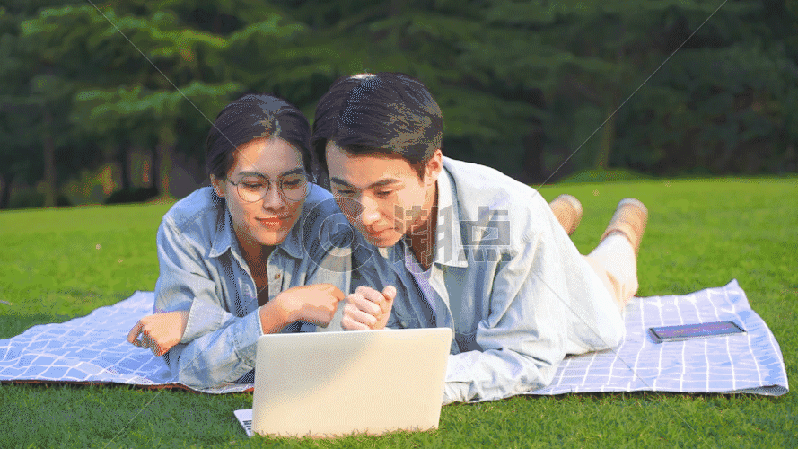 大学生在草地上使用电脑学习GIF图片素材免费下载