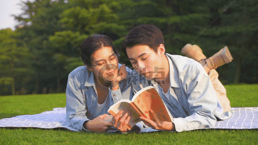 情侣在草坪上趴着看书GIF图片素材免费下载