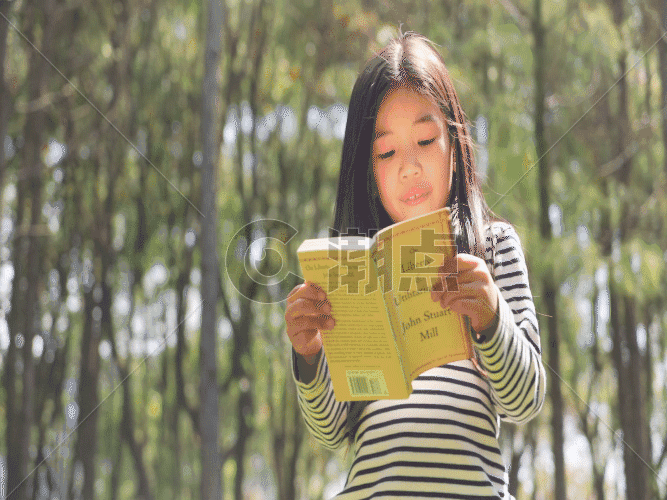 女孩站在草地上阅读GIF图片素材免费下载