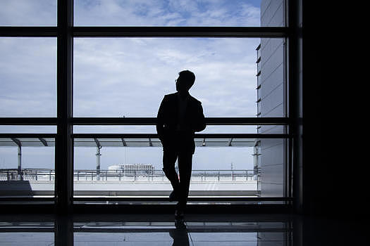 商务人士站在机场落地窗前图片素材免费下载