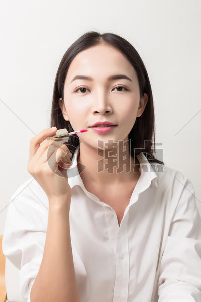化妆女人涂唇彩棚拍图片素材免费下载