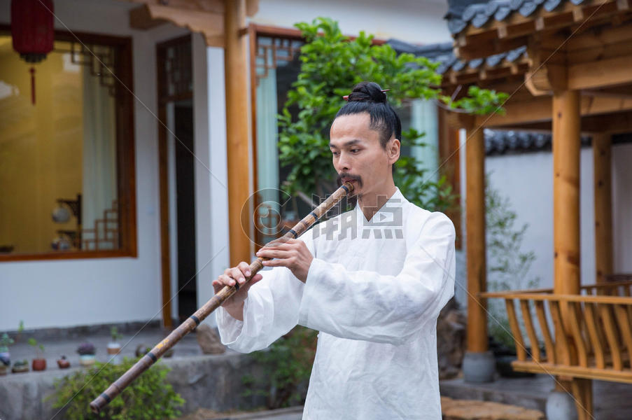 一位白衣道士在庭院内吹奏长笛图片素材免费下载