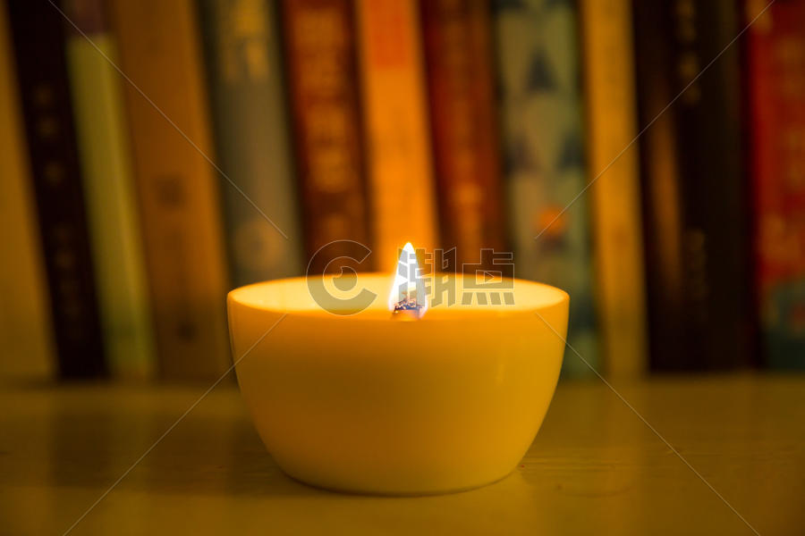 一杯燃烧的蜡烛放在书桌旁图片素材免费下载