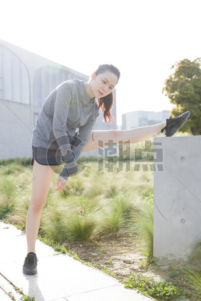 落日运动女孩在矮墙上压腿图片素材免费下载