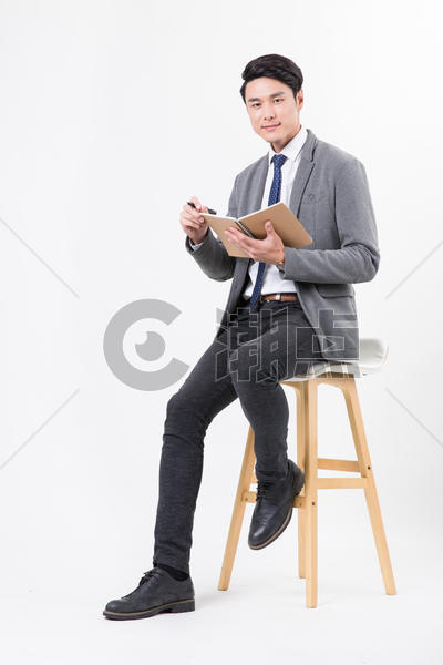 商务男士坐着用笔纸记录书写图片素材免费下载