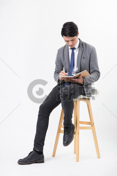 商务男士坐着用笔纸记录书写图片素材免费下载