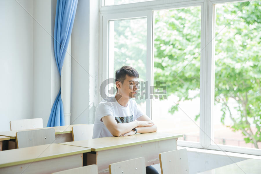 校园教室坐在窗户边的男生图片素材免费下载