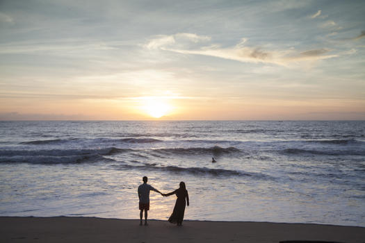 情侣在夕阳西下的海边看大海图片素材免费下载