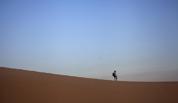 旅行中一个人孤独的在沙漠上行走图片素材免费下载