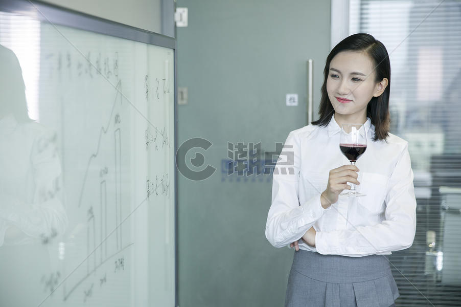 商务女士手举红酒看着会议板上数据图片素材免费下载