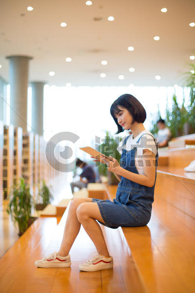 坐在图书馆使用平板的女生图片素材免费下载