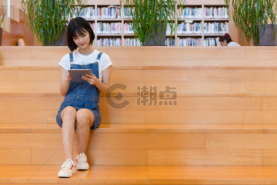 坐在图书馆使用平板的女生图片素材免费下载