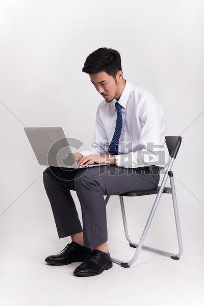坐着操作笔记本电脑的商务人士图片素材免费下载