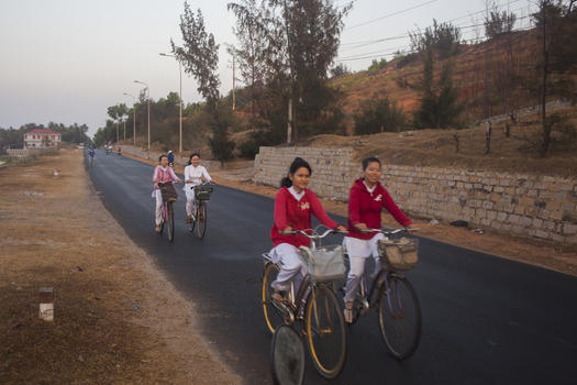 女学生们微笑骑车在上学路上图片素材免费下载