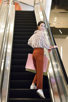 乘坐手扶梯逛街购物的美女图片素材免费下载