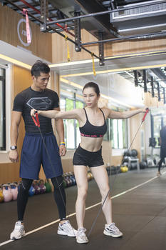 男教练在健身房给女性练习拉伸肌肉图片素材免费下载