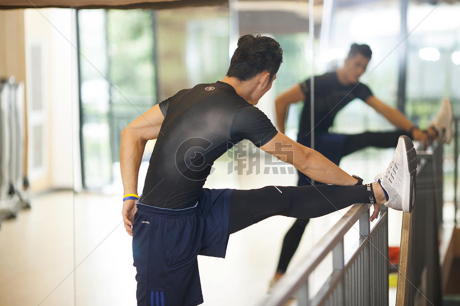 男性在健身房里练习压腿做热身运动图片素材免费下载