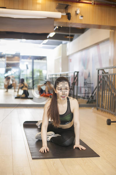 美女在健身房瑜伽垫上健身图片素材免费下载
