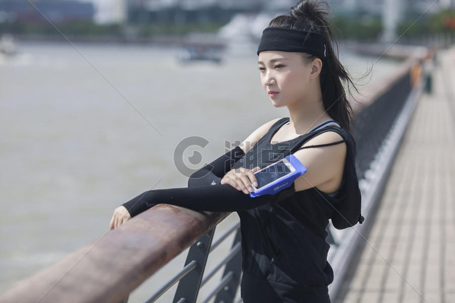 女性在户外运动时看臂弯手机图片素材免费下载