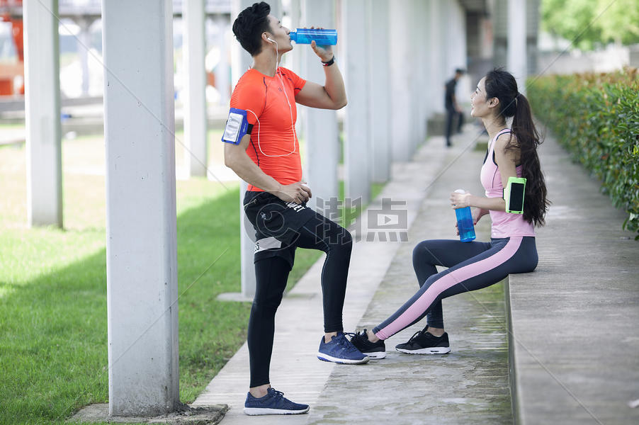 年轻男女在户外锻炼后休息喝水图片素材免费下载