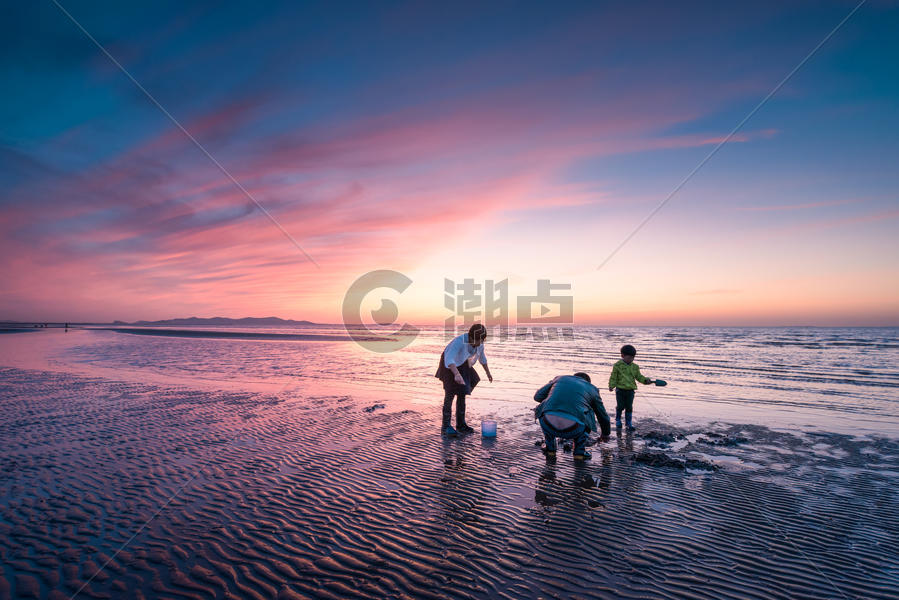 夕阳海滩上赶海的一家三口图片素材免费下载