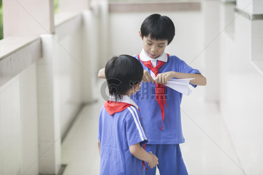 男学生在学校里折飞机玩耍图片素材免费下载